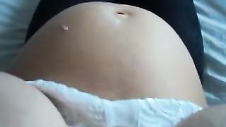 Pregnant cutie rubs her large stomach and fantastic natural tits