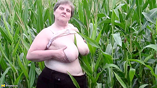 Perverted fatty fucks a fresh veggie deep into her loose old pussy in a corn field