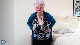 Mature buxom grey haired granny Caroline V. masturbates